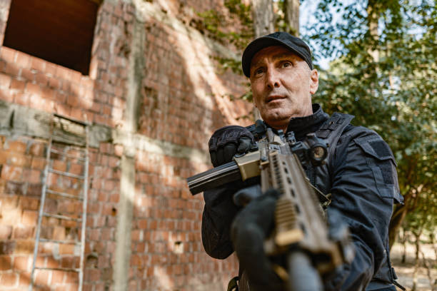 istock Single armed soldier tactical move beside brick building in military training 2170585647