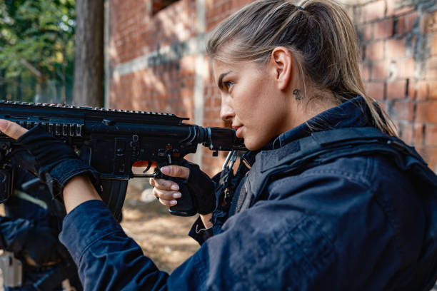 istock Single armed female soldier tactical move outside brick building in military training 2170585707