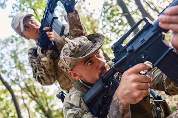 istock Two armed soldiers tactical move in wooded area during military training 2170586685