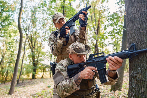 istock Two armed soldiers tactical move in wooded area during military training 2170586688
