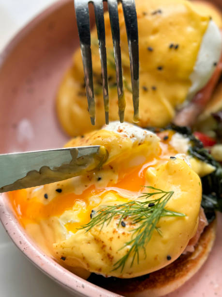 istock Image of savoring eggs royale  smoked salmon on benedict with poached eggs / healthy breakfast option / knife and fork in hand 2170588996