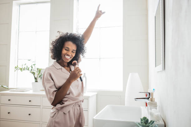 istock Smiling woman brushing teeth in bathroom 2170589366