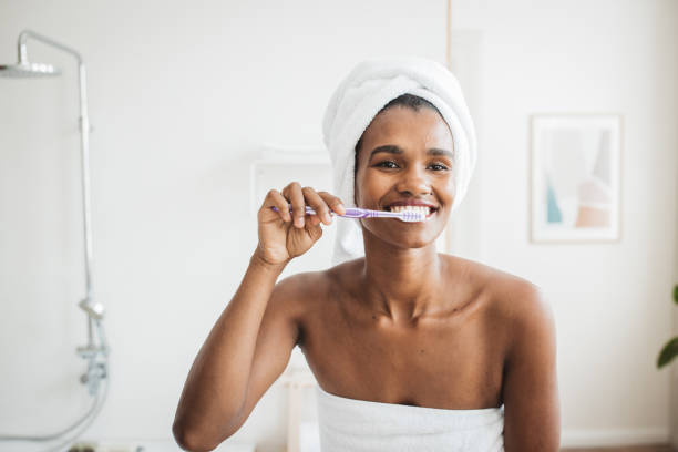 istock Smiling woman brushing teeth in bathroom 2170589416