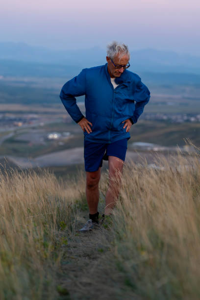 istock Senior man pauses in grasses at sunset 2170589450