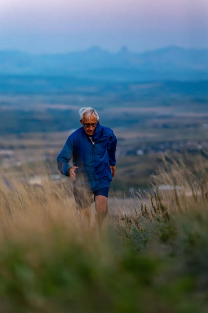 istock Senior man runs through grasses at sunset 2170589648