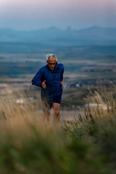 istock Senior man runs through grasses at sunset 2170589714