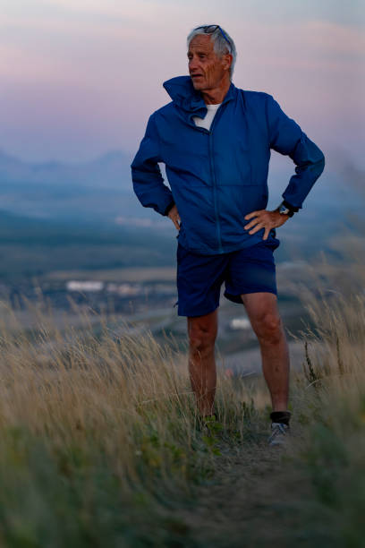 istock Senior man pauses in grasses at sunset 2170589770