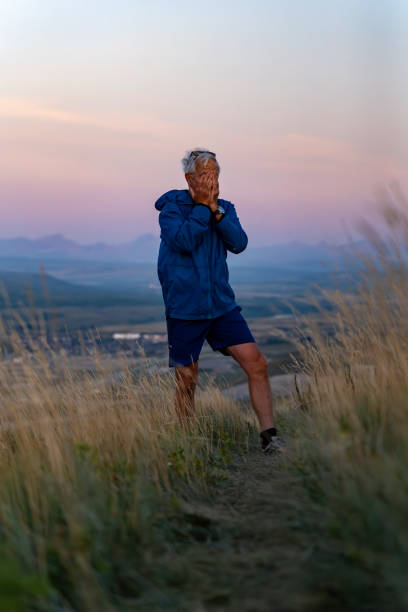 istock Senior man pauses in grasses at sunset 2170589786
