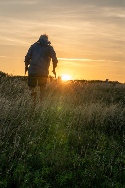 istock Senior man runs through grasses at sunset 2170589845