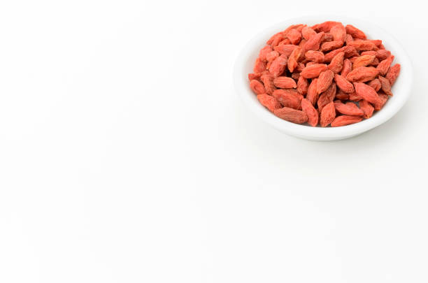 Dried goji berries on a plate on white background