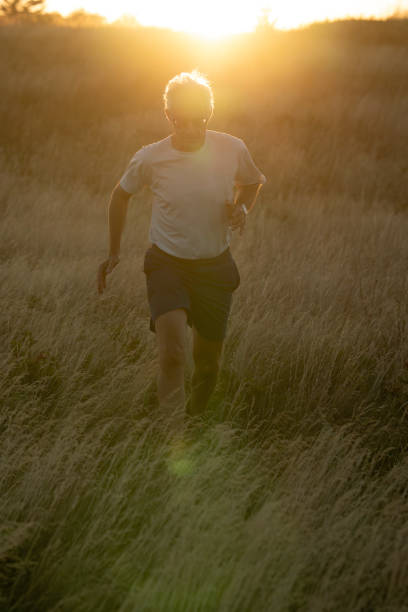 istock Senior man runs through grasses at sunset 2170590535