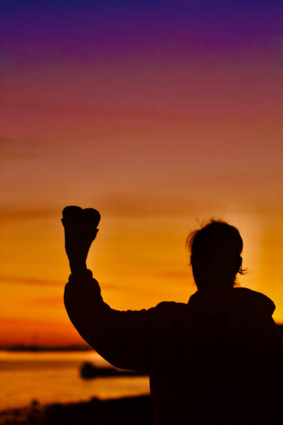 istock Holding Heart Rock in Silhouette at Sunset 2170590612