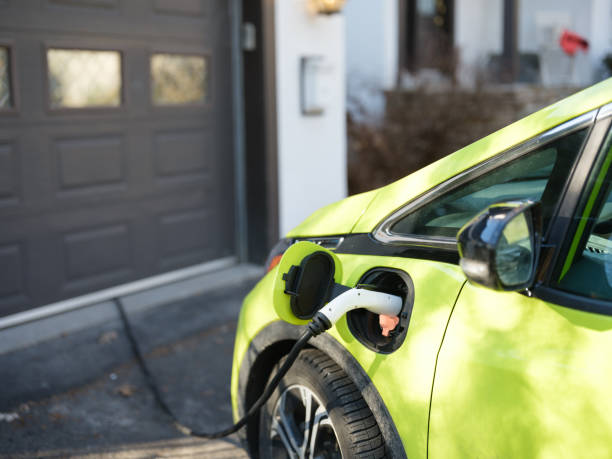 Electric car charging near garage in suburbs