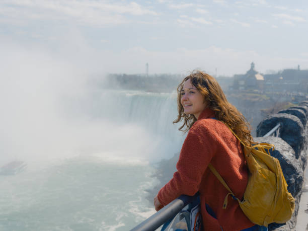 Scenic view of woman looking at Niagara Falls with awe during her trip