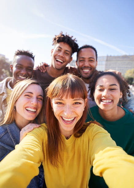 Group of happy friends posing for a selfie on a spring day as th Group of happy friends posing for a selfie on a spring day as they party together outdoors. Group of multicultural friends having a good time together on the weekend. selfie madrid photos stock pictures, royalty-free photos & images