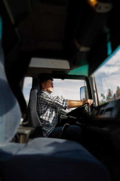 istock Vertical image, truck driver in the cabin on bright sunny day, looking ahead 2170598485