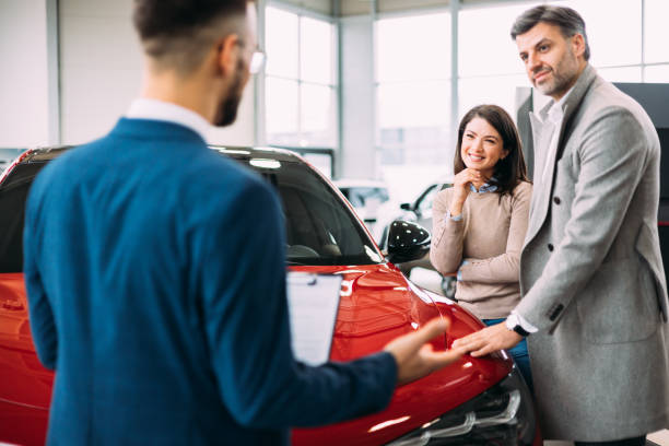 istock Car salesman discussing contract with couple 2170600423