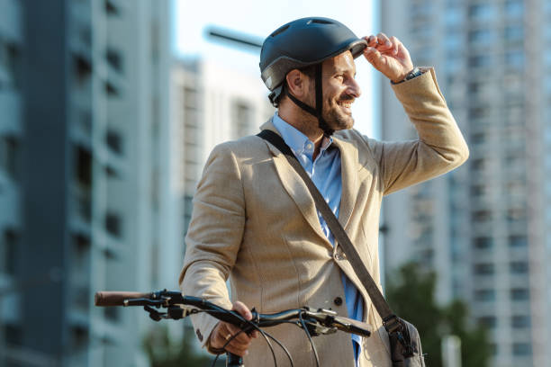 istock Smiling man with bicycle in an urban setting wearing a helmet 2170603126
