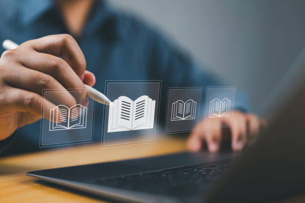 istock E-library concept. Person use laptop with virtual E-book icons for electronic books online, knowledge base on internet, digital library or e-library. 2170605026
