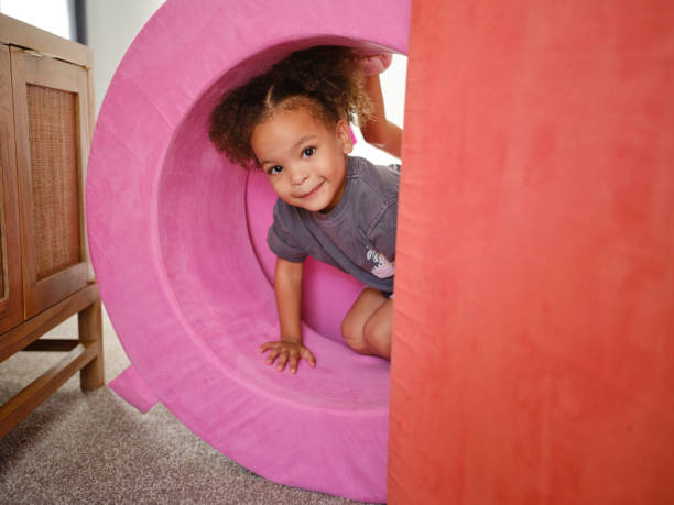 Children playing with cushions in a home living room.