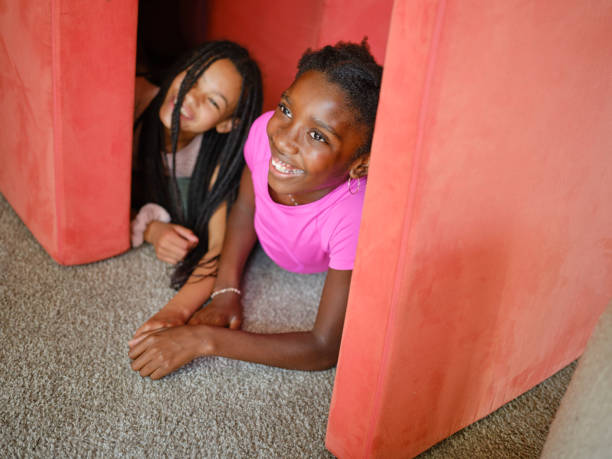 Two school-aged girls in casual orange and blue shirts reacting with surprise and excitement against a bright green backdrop, showcasing their expressive emotions and cheerful personalities. Perfect for educational and lifestyle themes.