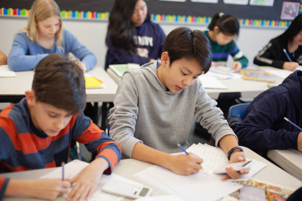 istock Asian multiracial Korean Japanese boy studies in elementary school classroom with classmates 2170615895