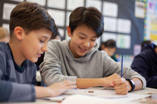istock Asian multiracial Korean Japanese boy studies in elementary school classroom with classmate 2170615937