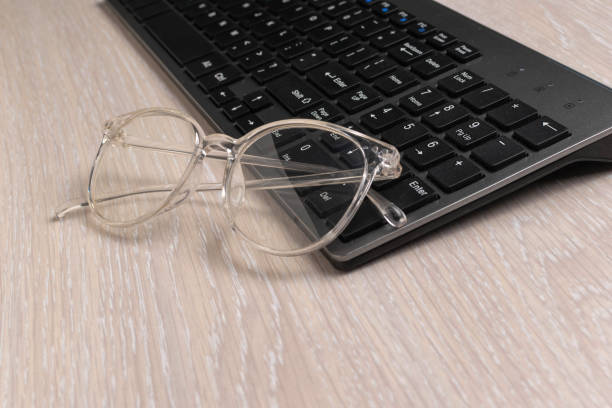 istock Transparent Glasses on Black Keyboard on Wooden Desk Technology Workspace 2170621795