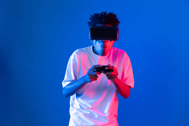 istock American African player wearing VR joystick neon lighting wall. Contrivance. 2170625433