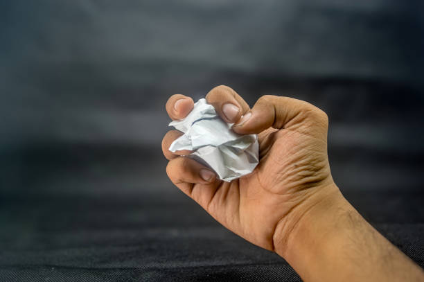 istock A hand squeezing a crumpled paper ball. 2170627248