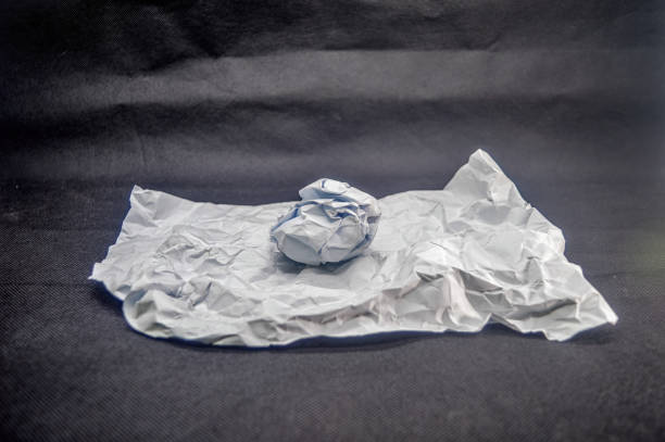 A textured paper background with a crumpled paper ball.