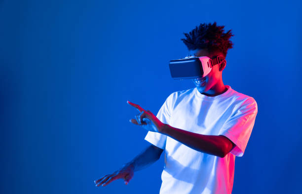 istock Young African player wearing VR point hologram 3D neon light wall. Contrivance. 2170627899