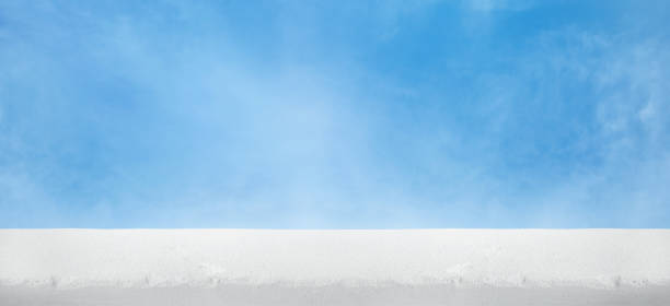 A minimalist scene featuring a flat expanse of white sand stone top on bright, clear blue sky. Perfect for backgrounds, travel themes, or summer design concepts.