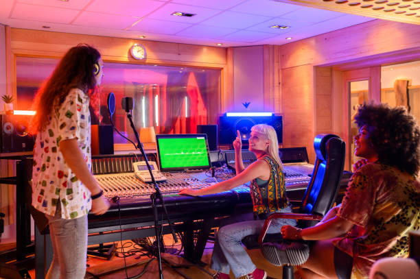 istock Singer singing a song while the producer is working on a soundboard in a studio 2170629495