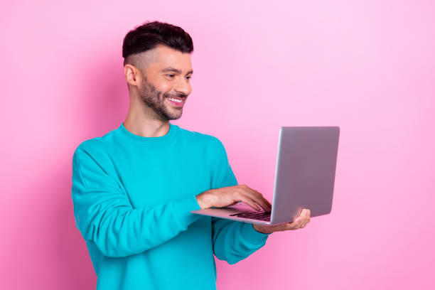istock Photo advert of young handsome student guy use his apple macbook browsing internet information about actual vacancy isolated on pink color background 2170632238