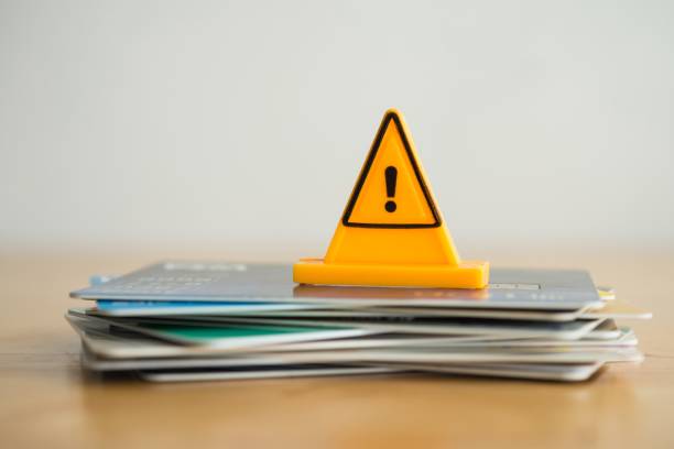 istock Close up yellow triangle emergency warning sign on many credit card white background. 2170636335