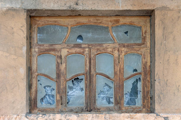 Old wooden window frame in Art Nouveau style with broken glass.