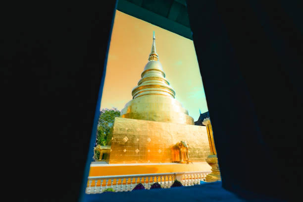 Ancient golden pagoda in window frame at Phra Singh Temple. Beautiful Buddhist art of Chiang Mai Province, Thailand.