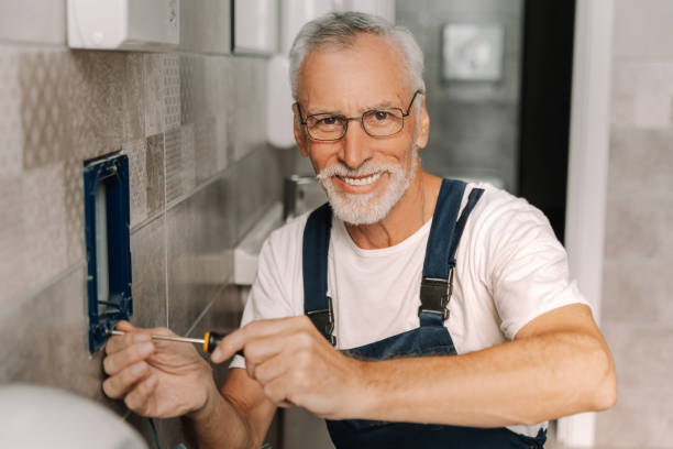 istock Electrician smiling installing a power outlet in a bathroom 2170643854