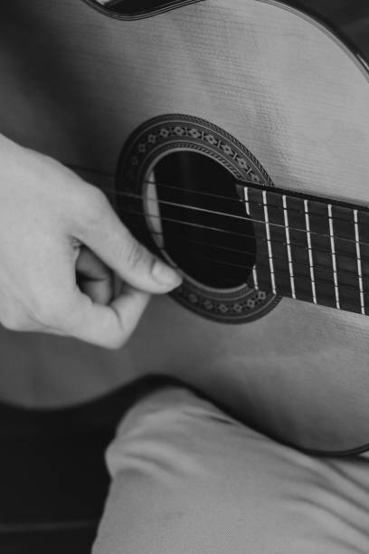 istock young men is playing acoustic guitar outside black and white 2170643945