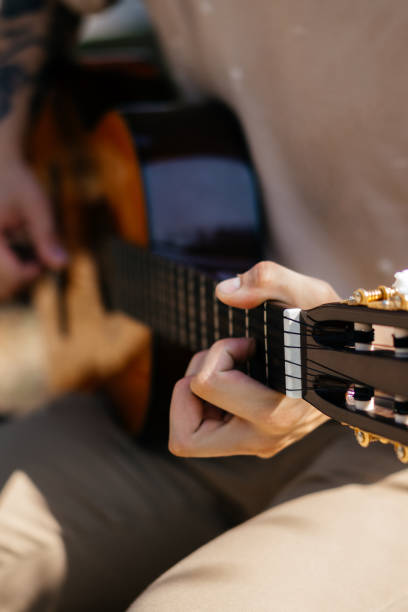 istock young men is playing acoustic guitar outside 2170644074