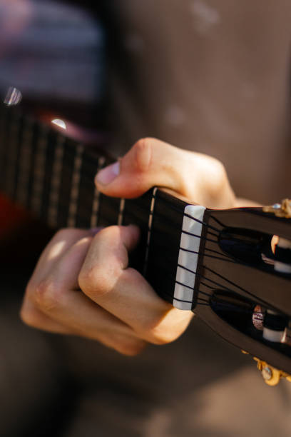 istock young men is playing acoustic guitar outside 2170644285