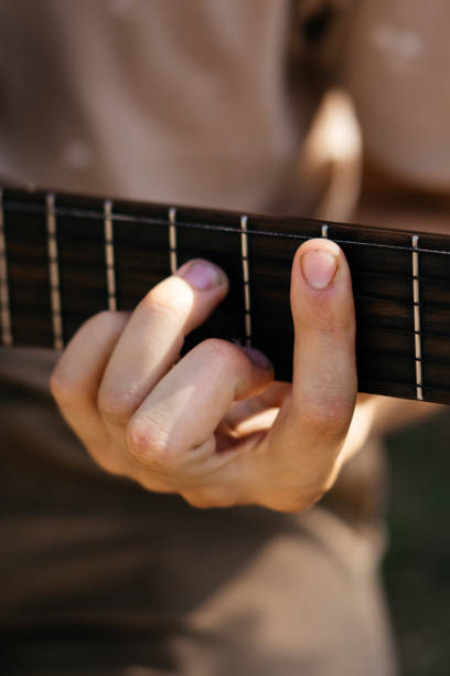 istock young men is playing acoustic guitar outside 2170644325