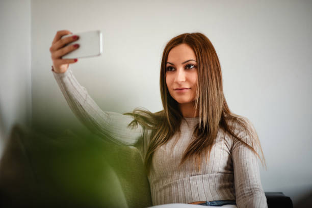 istock young woman taking selfie indoors 2170644725