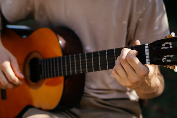 istock young men is playing acoustic guitar outside 2170644932
