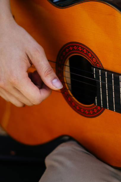 istock young men is playing acoustic guitar outside 2170645191