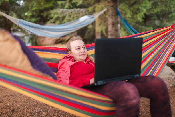 istock Young woman on a video call while relaxing in a hammock 2170649899