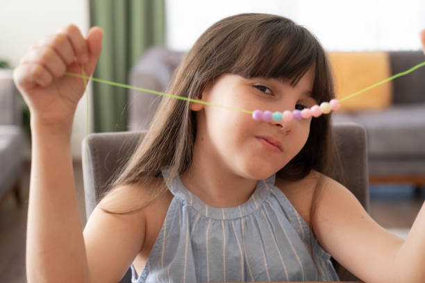 Little girl making bead bracelets