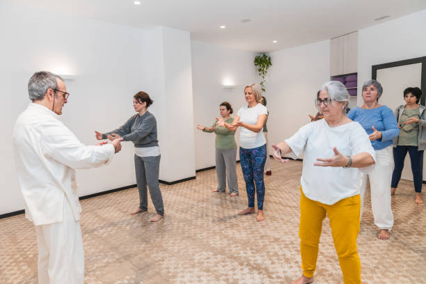 istock A group of people are practicing Tai Chi in a room 2170651139