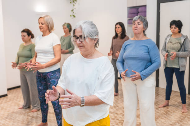 istock Group of senior women practicing mindful arm stretches during a yoga class 2170651377